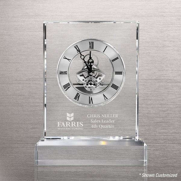 Transparent crystal clock showcasing intricate silver mechanical movement, desk‑top size on black crystal base.