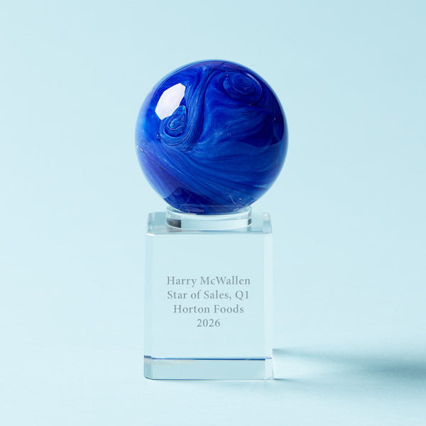 A blue marbled glass award sphere on a clear acrylic base engraved with the text 'Harry McWallen Star of Sales, Q1 Horton Foods 2026', set against a light blue background.