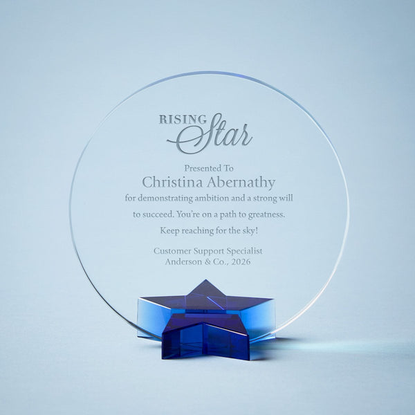 Rising Star employee recognition award featuring a round crystal-clear glass plaque and blue star base, customizable with recipient name, company logo, and achievement message.