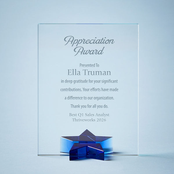 Clear crystal appreciation award plaque with engraved text and a blue star-shaped base, shown on a light blue background.