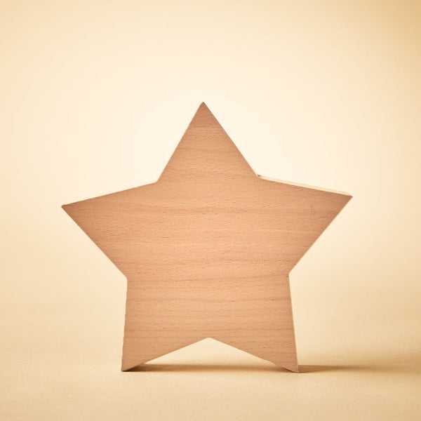 A light natural wood five-pointed star cutout standing upright on a warm beige background.