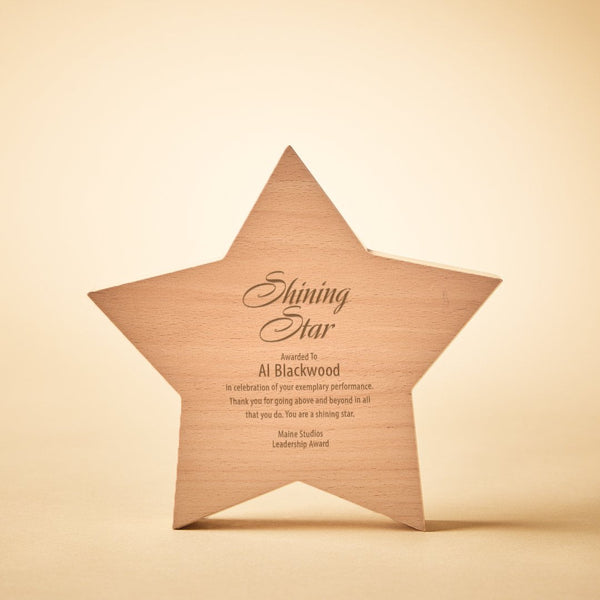 A personalized wooden star award plaque engraved with the text 'Shining Star Awarded to: Al Blackwood' on a warm beige background.