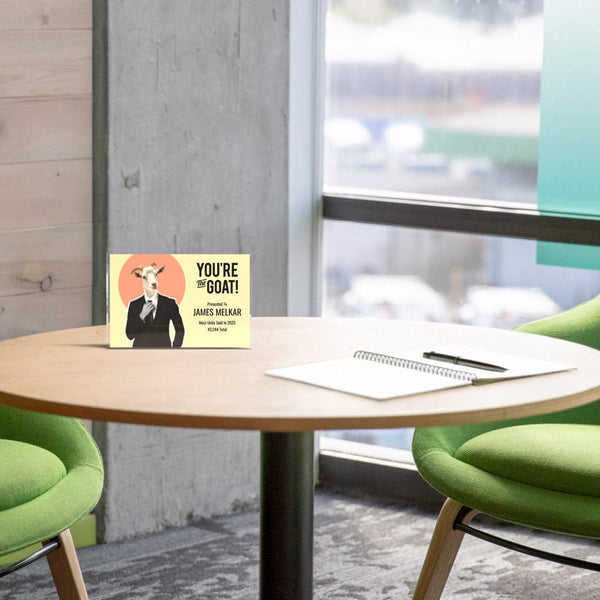 Table with an acrylic trophy reading 'You're the goat!' in an office setting